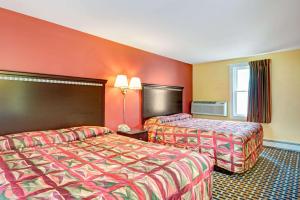 南波特兰Budget Inn的橙色墙壁的酒店客房内的两张床