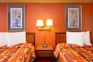 夏洛特港夏洛特港骑士酒店的橙色墙壁的酒店客房内的两张床