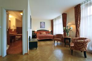 布拉格爱丽舍酒店的酒店客房带一张床、一张桌子和椅子