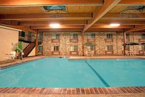 Monticello速8蒙蒂塞洛汽车旅馆的酒店的大型游泳池配有桌椅