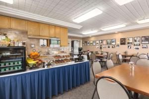 Spruce Grove云杉林之旅汽车旅馆的一间设有桌子和食品柜台的自助餐厅