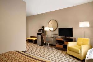 赫尔希Super 8 by Wyndham Hershey Chocolate Avenue的酒店客房配有一张床和一张书桌及一台电视
