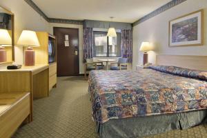 科默斯洛杉矶康莫斯区旅程住宿酒店的酒店客房配有一张床铺和一张桌子。