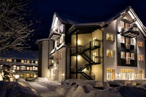 施马伦贝格兰德温德托米斯科尔酒店的一座晚上下雪的建筑