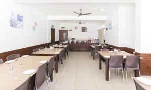 库斯哈尔纳加尔Treebo Trend Sandpipers Kushalnagar的用餐室配有木桌和椅子