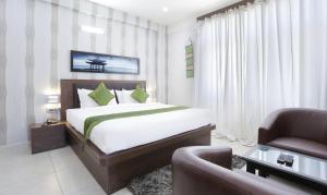 库斯哈尔纳加尔Treebo Trend Sandpipers Kushalnagar的一间卧室配有一张床、一把椅子和一张沙发