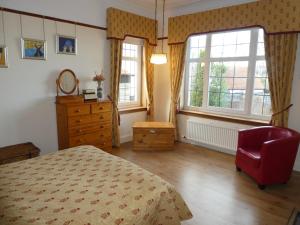 爱丁堡The Cairn Residence的一间卧室配有一张床、一个梳妆台和两个窗户。