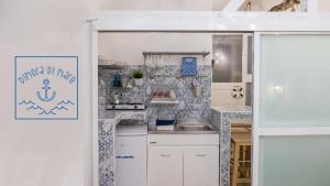 特拉尼Dimora Di Mare的小厨房配有白色橱柜和水槽