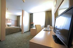 耶莱尼亚古拉Hotel Cieplice MEDI & SPA的酒店客房设有电视和床。