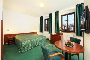 捷克克鲁姆洛夫麦林酒店的酒店客房配有一张床铺和一张桌子。