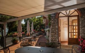 皮特拉利古伊尔卡畔诺旅馆的一个带桌椅和遮阳伞的户外庭院。