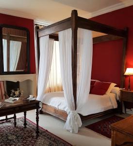索米尔蟠龙旅馆的一间卧室配有一张天蓬床和一张桌子