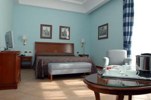 那不勒斯那不勒斯里奇米尼商务酒店的酒店客房配有一张床和一张茶几