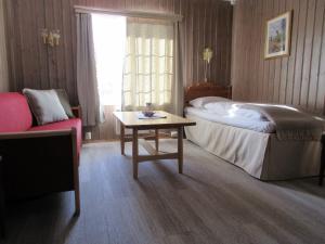 Dovre托福默旅馆的一间卧室配有一张床、一张桌子和一张沙发