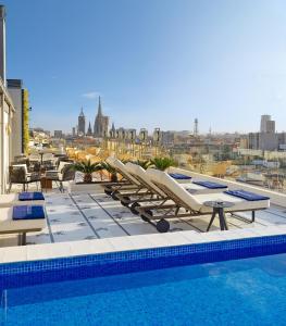 巴塞罗那H10立方体4 *索普酒店的一个带躺椅的游泳池,享有城市美景