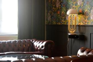 柏林Linnen Luxx Apartment的客厅配有真皮沙发和灯具