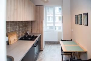蒂米什瓦拉Ultracentral, brand new, modern and cozy apartment的厨房配有炉灶、桌子和窗户。