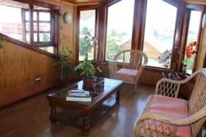 蒙特港Hostal Lagunitas的客厅配有桌椅和窗户。