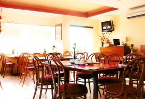卡门城Hotel del Parque的一间带木桌和椅子的用餐室