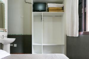 圣保罗Hotel Residenza - 400m do inicio da Av Paulista e Metrô Paraiso的一间卧室配有白色橱柜和电视机