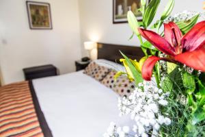 门多萨门多萨酒店 的一间卧室,配有一张床和花瓶