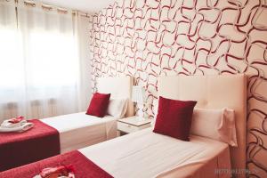 巴达洛纳阿尔坎巴达洛纳北海滩酒店的红色和白色的客房内的两张床