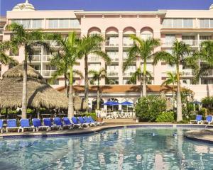 棕榈滩海岸Palm Beach Shores Resort and Vacation Villas的一座带蓝色椅子的游泳池和一座建筑