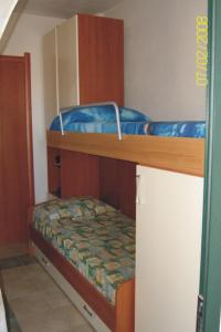 西尼斯科拉Villetta Mirto的客房设有两张双层床和一张小床。