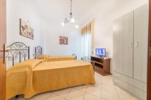 梅利萨诺Salento Sweet Home的一间卧室配有黄色的床和电视
