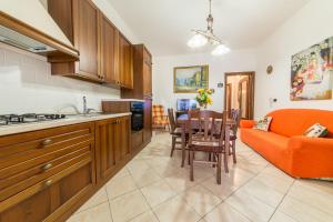 梅利萨诺Salento Sweet Home的厨房以及带橙色沙发的起居室。