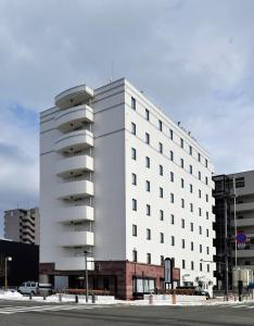 盛冈盛冈站前金酒店的一条城市街道上的白色大建筑