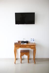 坎古Grandpa Guest House的一张木桌,墙上挂着电视