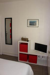 迪耶普Appartement Quai Ouest的一间卧室配有电视和一张带红色抽屉的床