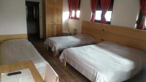 拉夫纳格拉Pansion i restoran Bijela Ruža的酒店客房带两张床和两个窗户