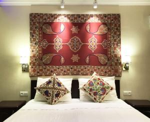 撒马尔罕Jahongir Guest House的一间卧室配有一张红色床头板的床