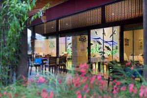 贝莱克暹罗典雅Spa酒店的前景餐厅,配有桌椅和鲜花