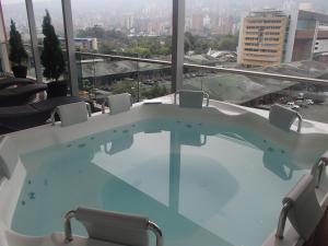 麦德林Hotel Sixtina Plaza Medellin的享有城市景观的客房内的热水浴池