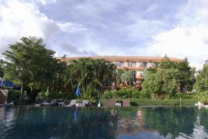 查汶PTK公寓酒店的一座带椅子的游泳池以及一座建筑
