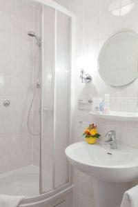 柏林贝恩酒店的带淋浴和盥洗盆的白色浴室
