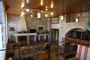 阿里奥波利斯玛尼酒店的一个带壁炉和石墙的大客厅