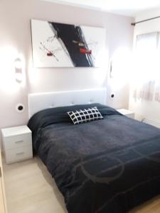 科马鲁加Apartamento Torre Sant Salvador的一间卧室配有一张大床和黑色棉被