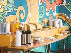莫罗圣保罗莫罗圣保罗拉加托旅馆的一张桌子,上面放着食物盘子和五颜六色的墙壁