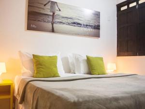 莫罗圣保罗莫罗圣保罗拉加托旅馆的一间卧室配有带绿色和白色枕头的床