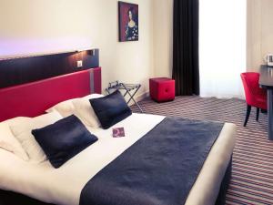 昂古莱姆法国昂古莱姆美居酒店的一间卧室配有一张大床和红色床头板