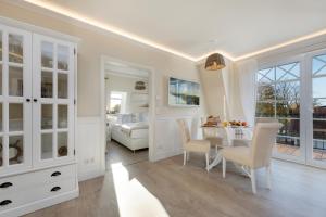 青斯特Villa Strandblick 8的白色的客房设有餐桌和一间卧室。