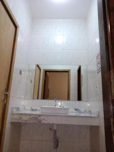 巴乌鲁Ipê Rosa Hotel的一间带水槽和大镜子的浴室