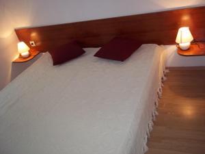 沃迪切Vila Ivančica 2的一间卧室配有一张带两盏灯的大型白色床。