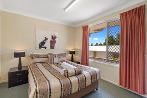 土乌巴Clifford Park Motor Inn的一间卧室设有一张床和一个窗口