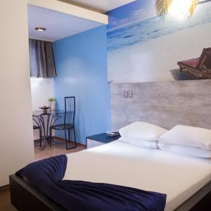 伊图佩瓦彩虹汽车旅馆（仅限成人）的一间卧室配有一张海滩绘画床