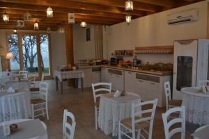 蒙赞巴诺Agriturismo Olistico Atman的厨房以及带白色桌椅的用餐室。